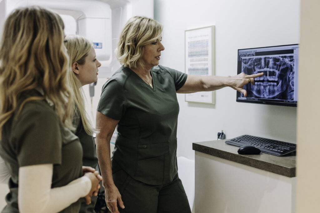 Dr. Sharon Dickerson and team reviewing 3D cone beam imaging for biological endodontic diagnosis in Denver