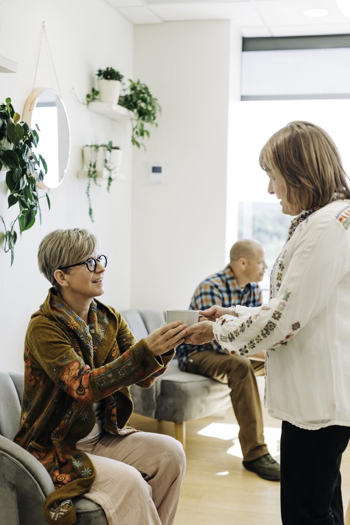 Patient welcomed with a cup of tea in the calm waiting area of a holistic dental office in Denver